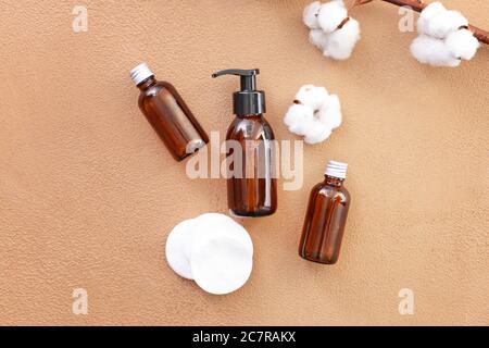 Flaschen Baumwollsaatenöl mit kosmetischen Pads auf farbigem Hintergrund Stockfoto