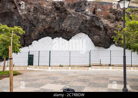 Unbesetztes altes Höhlenhaus mit weißer Wand und eingezäunt, um es als historisches Merkmal in Playa San Juan, Teneriffa, Kanarische Insel zu erhalten Stockfoto