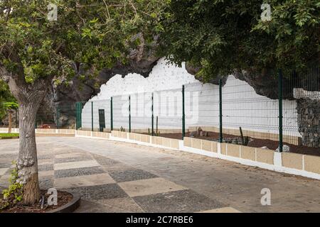 Unbesetztes altes Höhlenhaus mit weißer Wand und eingezäunt, um es als historisches Merkmal in Playa San Juan, Teneriffa, Kanarische Insel zu erhalten Stockfoto