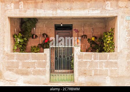 Ungerendertes, einstöckiges Haus aus Ziegel und Beton mit vielen Pflanzen in einer Seitenstraße in Playa San Juan, Teneriffa, Kanarische Inseln, Spanien Stockfoto