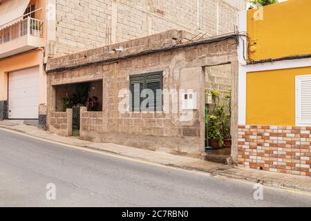 Ungerendertes, einstöckiges Haus aus Ziegel und Beton mit vielen Pflanzen in einer Seitenstraße in Playa San Juan, Teneriffa, Kanarische Inseln, Spanien Stockfoto