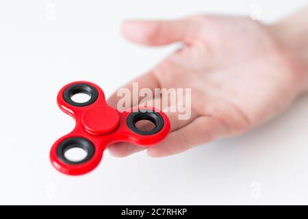 Nahaufnahme des Fidget Spinner in weiblicher Hand über weißem Hintergrund Stockfoto