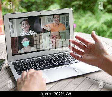 Frau mit Videoanruf und Chat mit Familie über Computer Laptop zu Hause mit Blick auf den Garten Stockfoto