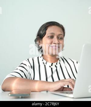 Happy Indian ethnischen Business Frau lächeln und tippen auf dem Computer Laptop. Stockfoto