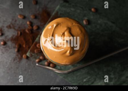 Glas leckeren Dalgona Kaffee auf dunklem Hintergrund Stockfoto