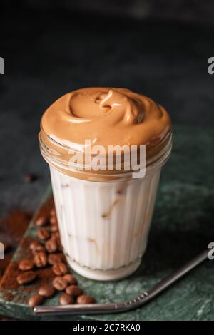 Glas leckeren Dalgona Kaffee auf dunklem Hintergrund Stockfoto