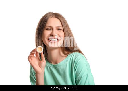 Schöne junge Frau mit Lippenbalsam auf weißem Hintergrund Stockfoto