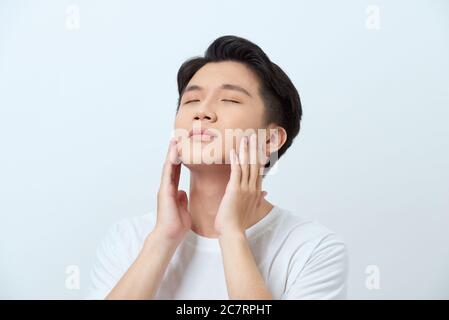 Schöner Mann berührt sein Gesicht Nahaufnahme portrait Studio auf weißem Hintergrund Stockfoto