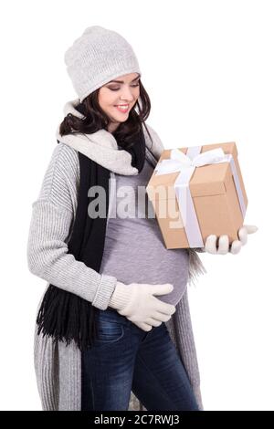 Schöne schwangere Frau in warmen Winterkleidung mit Geschenkbox isoliert auf weißem Hintergrund Stockfoto