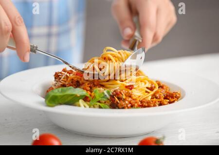 Frau essen leckere Pasta Bolognese in der Küche, Nahaufnahme Stockfoto