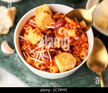 Essen von leckeren Nudeln und Bohnen in Schüssel, Nahaufnahme Stockfoto