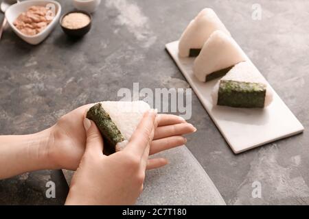 Frau bereitet traditionelle japanische onigiri auf dem Tisch Stockfoto