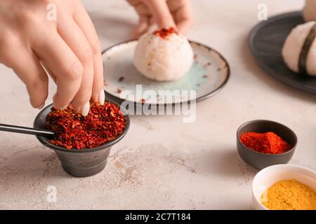 Frau bereitet traditionelle japanische onigiri auf dem Tisch Stockfoto