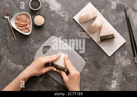 Frau bereitet traditionelle japanische onigiri auf dem Tisch Stockfoto