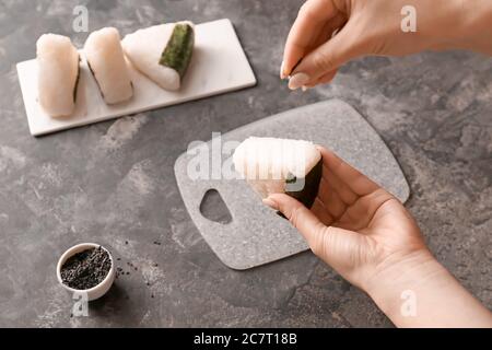 Frau bereitet traditionelle japanische onigiri auf dem Tisch Stockfoto