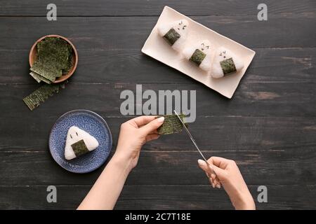 Frau bereitet traditionelle japanische onigiri auf dem Tisch Stockfoto