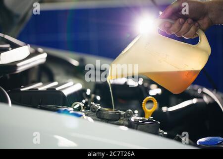 Der Automechaniker wechselt das Motoröl in einen Motor an der Autostation Stockfoto