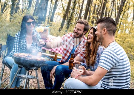 Stattliche glücklich männlichen Vorbereitung Grill im Freien für Freunde Stockfoto