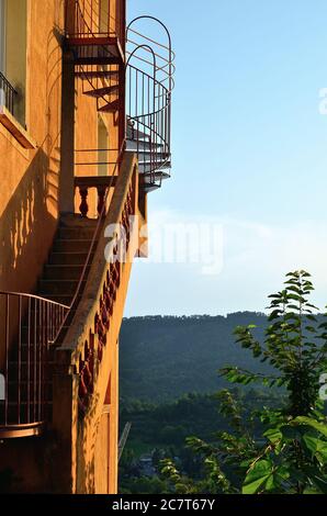 Außentreppe auf einem alten Haus und Blick vom mittelalterlichen Dorf Moustiers Sainte Marie auf ländliche Landschaft bei Sonnenuntergang. Provence, Frankreich Stockfoto