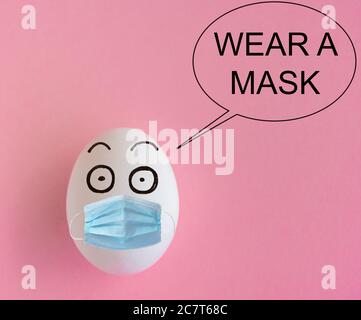 Gesichter auf den Eiern, Coronavirus-Ausbruchsverhütungskonzept, tragen eine Maske Stockfoto