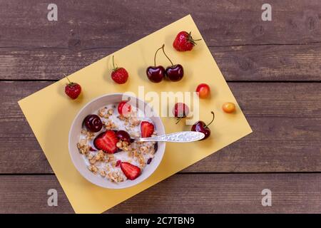 Gesundes Frühstück.Müsli mit Milch und Beeren - Gesundheits- und Diät-Konzept.Vegetarisches Frühstück. Haferflocken, Müsli mit Erdbeeren und Kirsche in einer Schüssel Stockfoto