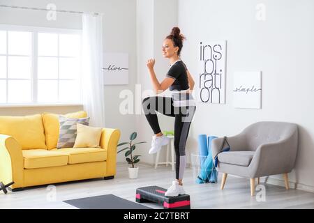 Sportliche junge Frau Training zu Hause Stockfoto