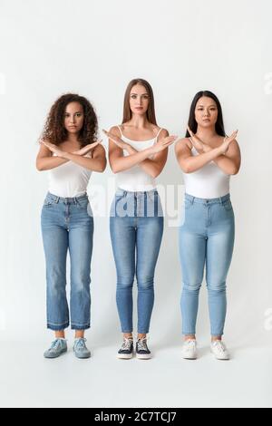 Frauen verschiedener Nationalitäten zeigen STOP-Geste auf weißem Hintergrund. Konzept des Rassismus Stockfoto