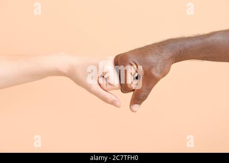 Kaukasische Frau und afroamerikanischen Mann stoßen Fäuste auf Farbe Hintergrund. Rassismus-Konzept Stockfoto