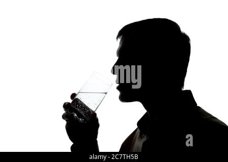 Junger Mann trinkt ein Glas Sekt - Silhouette Stockfoto