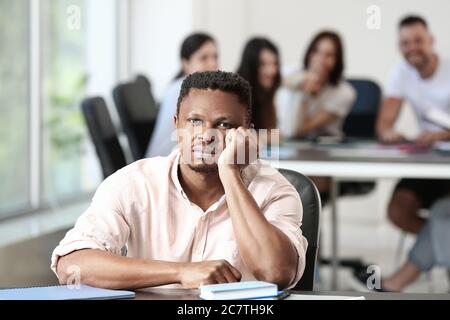 Einsamer afroamerikanischer Mann im Büro. Stoppen Sie Rassismus Stockfoto