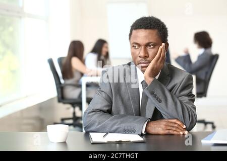 Einsamer afroamerikanischer Geschäftsmann im Büro. Stoppen Sie Rassismus Stockfoto