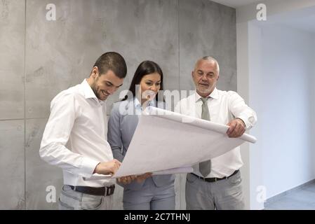Immobilienmakler zeigt den Plan der neuen Wohnung An ein junges Paar Stockfoto