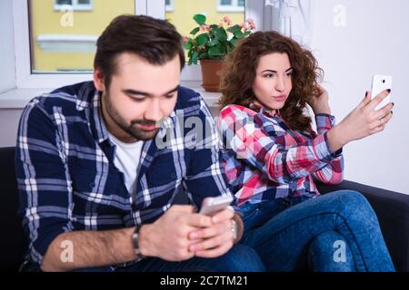 Social Network sucht Konzept - Mann mit Smartphone und seine Freundin Selfie-Foto zu Hause Stockfoto