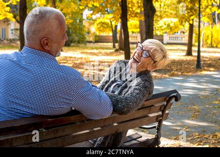 Ältere Paar lachen und Spaß auf einer Parkbank Stockfoto