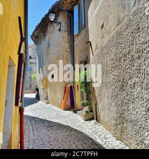 SEGURET, FRANKREICH - 11. JUL 2014: Enge mittelalterliche Straße in kleinem Dorf Seguret, eines von der Liste der schönsten Dörfer in der Provence. Stockfoto