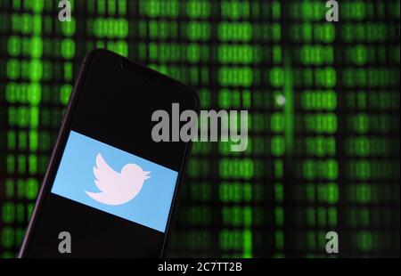 Viersen, Deutschland - 9. Juli. 2020: Blick auf Handy mit twitter-Logo von Hand halten. Bildschirm mit Tunnel von binären Code-Nummern Hintergrund.(selektiv Stockfoto