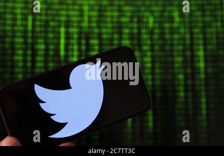 Viersen, Deutschland - 9. Juli. 2020: Blick auf Handy mit twitter-Logo von Hand halten. Bildschirm mit Tunnel von binären Code-Nummern Hintergrund.(selektiv Stockfoto
