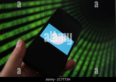 Viersen, Deutschland - 9. Juli. 2020: Blick auf Handy mit twitter-Logo von Hand halten. Bildschirm mit Tunnel von binären Code-Nummern Hintergrund.(selektiv Stockfoto