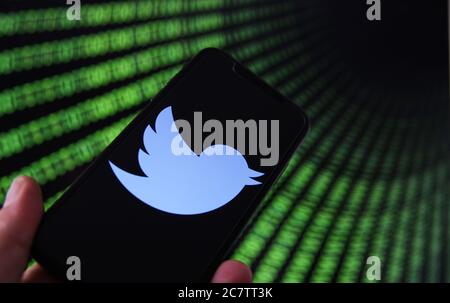 Viersen, Deutschland - 9. Juli. 2020: Blick auf Handy mit twitter-Logo von Hand halten. Bildschirm mit Tunnel von binären Code-Nummern Hintergrund.(selektiv Stockfoto