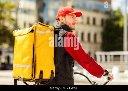 Kurier Mit Gelbem Rucksack Liefert Essen Auf Fahrrad Reiten Draußen Stockfoto