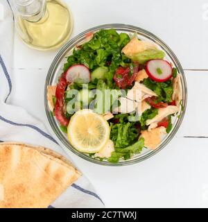 Schale von Fattoush libanesischer Salat mit Pita-Brot auf weißem Holztisch Stockfoto