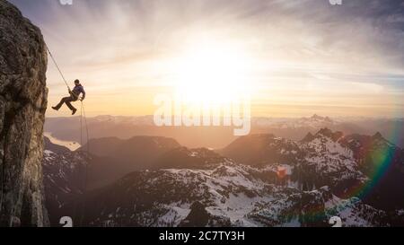 Episch abenteuerliche Extreme Sport Composite von Rock Climbing man Abseilen von einer Klippe. Stockfoto