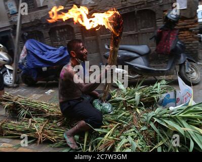 Kathmandu, Nepal. Juli 2020. Ein Mann verkleidet sich als Dämon trägt brennendes Feuer, während Menschen das Bildnis des Dämons ziehen, um in Fluss auf Ghantakarna Festival in Kathmandu, Hauptstadt von Nepal am 19. Juli 2020 zu werfen. Die Newar-Gemeinde des Kathmandu-Tals beobachtet Ghantakarna, ein Fest, um böse Geister zu vertreiben und Glück zu bringen. Menschen tragen Metallringe, um sich vor allen Übel und bösen Geistern zu schützen. Kredit: Sunil Sharma/ZUMA Wire/Alamy Live Nachrichten Stockfoto