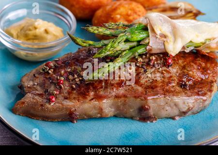 Grüner Spargel auf einem Steak Stockfoto