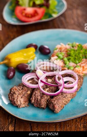Cevapcici mit djuvec Reis auf Holz Stockfoto