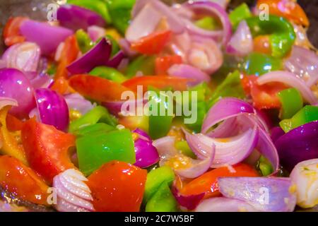 Rühren Sie gebratenes buntes Gemüse im Wok, gesunde Lebensmittel. Konzept für eine leckere und gesunde vegetarische Mahlzeit. Nahaufnahme Stockfoto
