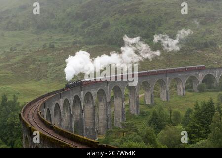 Glenfinnan Viaduct, Schottland, Großbritannien. Der Jacobite Dampfzug, liebevoll als Hogwarts Express bekannt, überquert das Glenfinnan Viadukt. Stockfoto