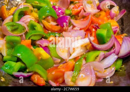 Rühren Sie gebratenes buntes Gemüse im Wok, gesunde Lebensmittel. Konzept für eine leckere und gesunde vegetarische Mahlzeit. Nahaufnahme Stockfoto