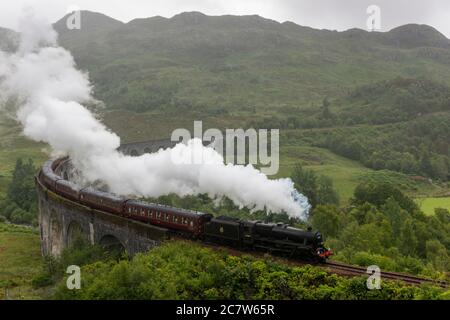 Glenfinnan Viaduct, Schottland, Großbritannien. Der Jacobite Dampfzug, liebevoll als Hogwarts Express bekannt, überquert das Glenfinnan Viadukt. Stockfoto