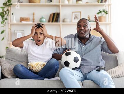 Tor Verloren. Enttäuscht Black Großvater und sein Enkel Fußball im Fernsehen Stockfoto